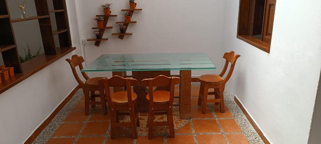 a glass table and chairs in a room at Los Pinos in Jardin