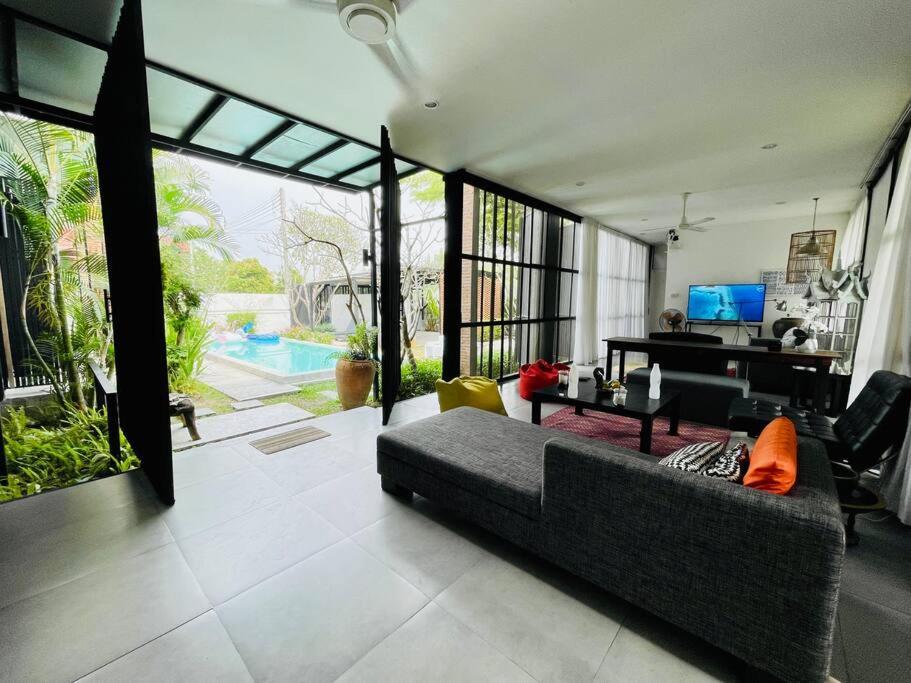 a living room with a couch and a table at Ren pool villa 清迈3卧泳池别墅 in Chiang Mai