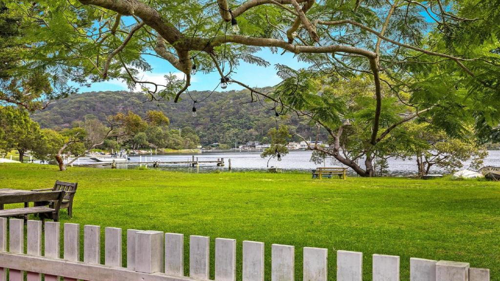 a park with benches and a fence and a lake at Mi Casa - Patonga Beach My House in Patonga