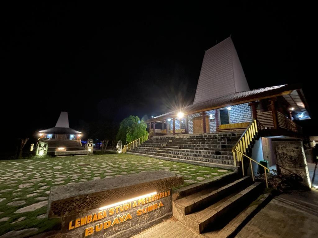 un edificio con escaleras y un cartel en la noche en Rumah Budaya Sumba, en Lokokaki