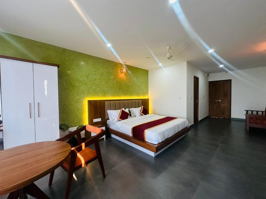 Mary Land Residency في Meenangadi: غرفة نوم فيها سرير وطاولة فيها