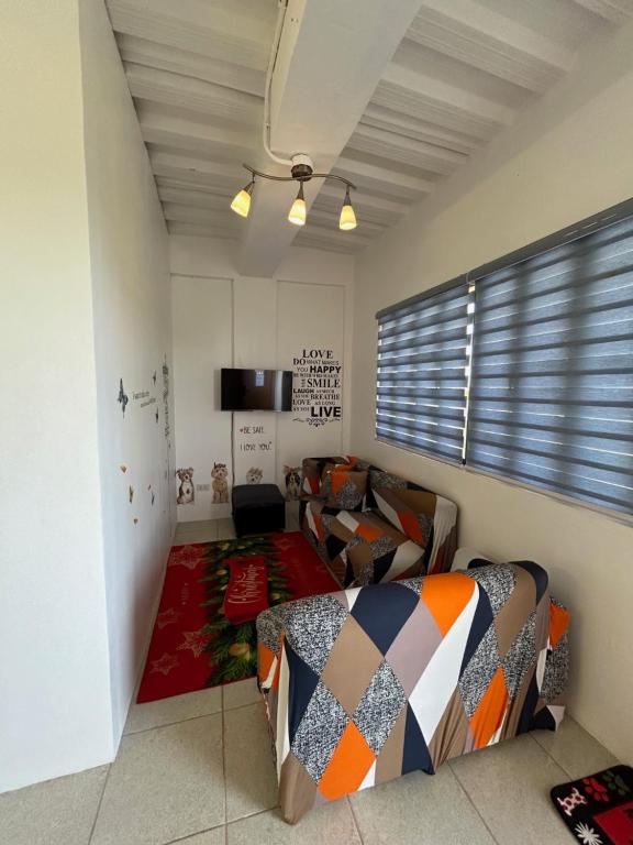SilangにあるCaishen Modern Affordable Apartelle 302のベッドルーム(ベッド1台、ソファ、テレビ付)