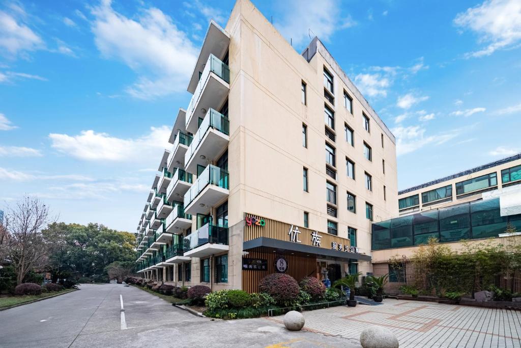 un edificio blanco alto al lado de una calle en Yozo Serviced Apartment, en Shanghái