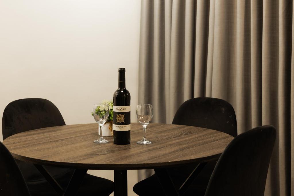 a bottle of wine sitting on a wooden table with two glasses at Lev Yerushalayim Hotel in Jerusalem