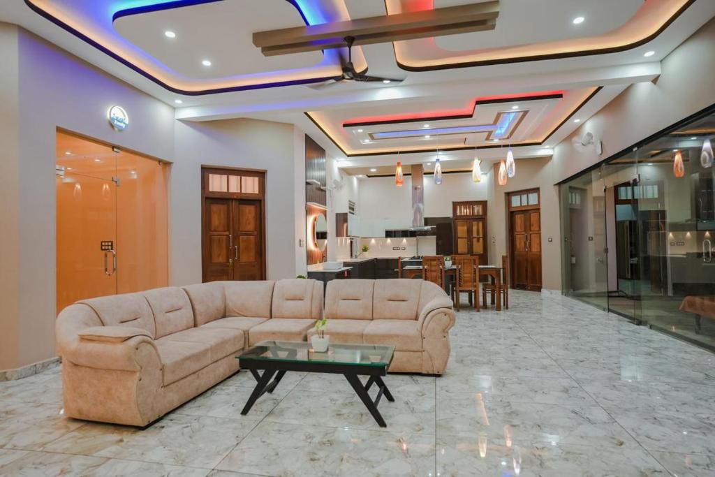 Thalir Resort في أليبي: غرفة معيشة مع أريكة وطاولة