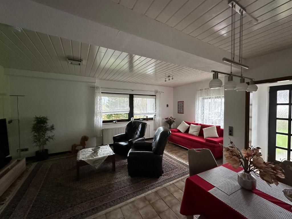a living room with a red couch and chairs at Apartment58 in Wiehl