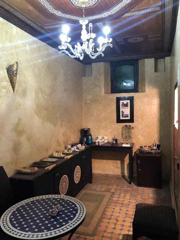a kitchen with a table and a chandelier at Dar Bargach in Tangier