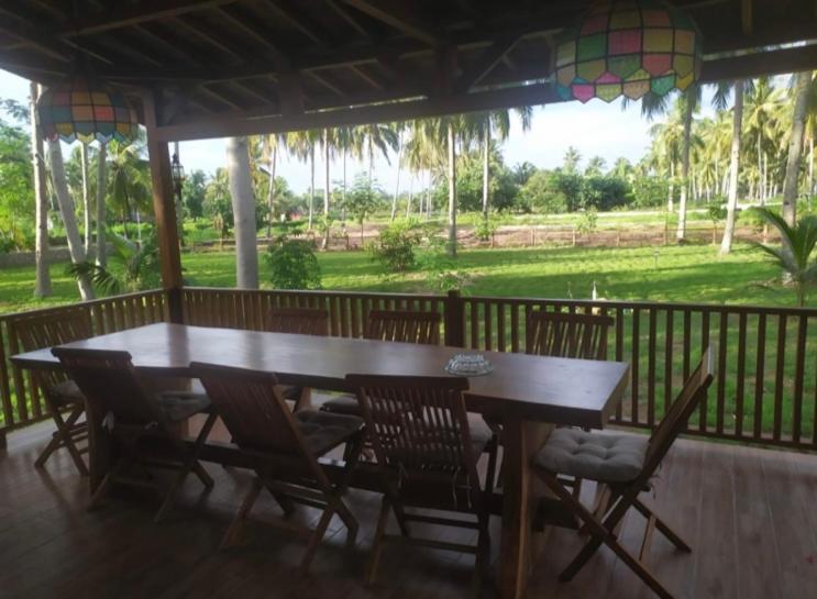 Puri Sanghyang في Batukaras: طاولة وكراسي خشبية على شرفة