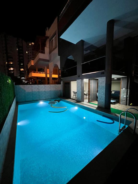 a large swimming pool in a building at night at Müstakil Alt Kat Havuzlu Villa in Erdemli