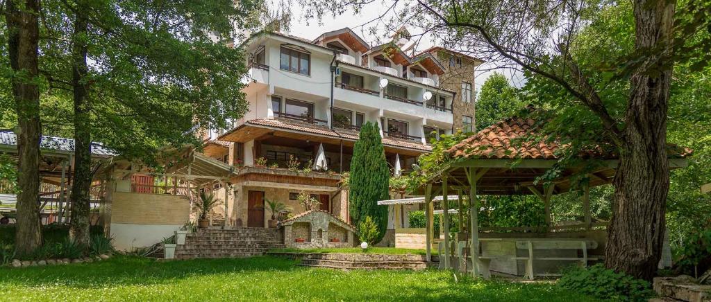 une grande maison au milieu de quelques arbres dans l'établissement Hotel Paradise Place, à Kalofer