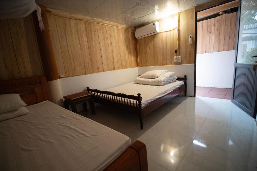 a small bedroom with two beds and a table at Homestay Long Coc in Phú Thọ