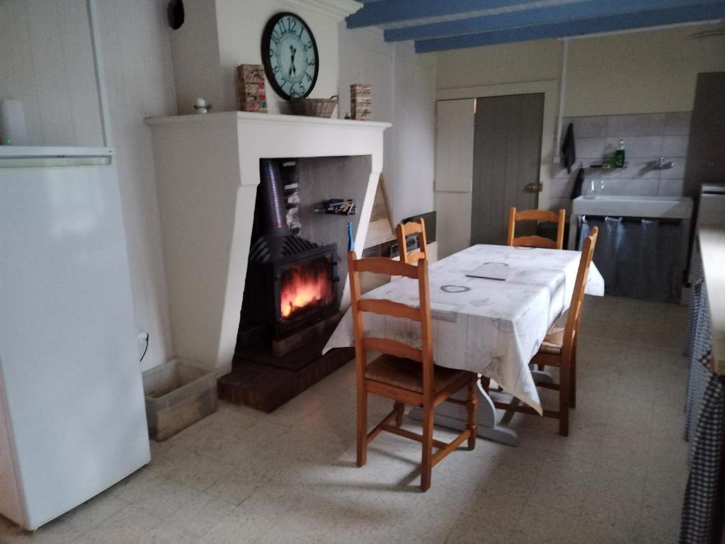 a dining room with a table and a fireplace at Gîte du Gardoir in Boresse-et-Martron
