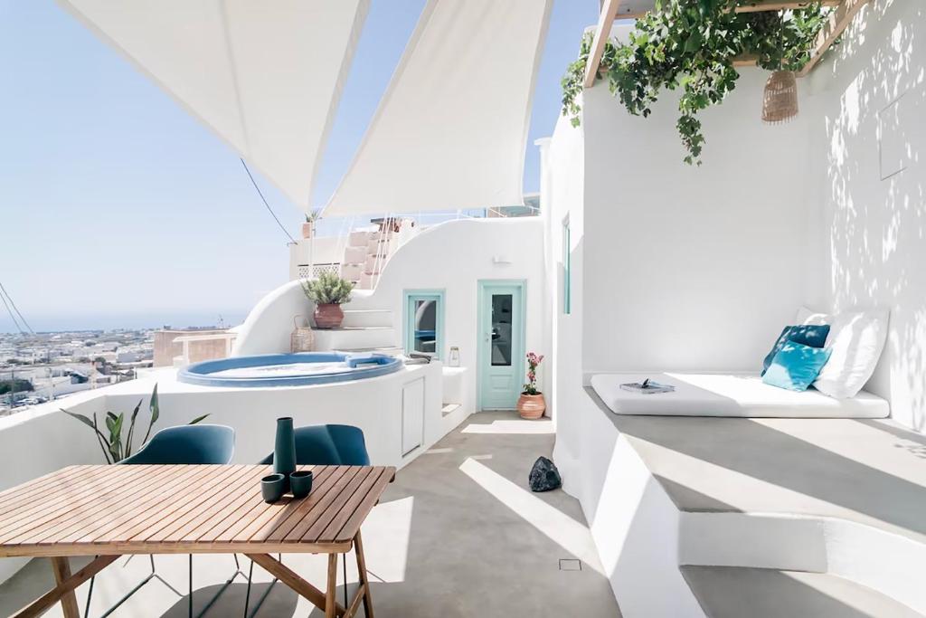 balcone con pareti bianche, tavolo e sedie di Vima Santorini, Traditional Luxury a Emporio