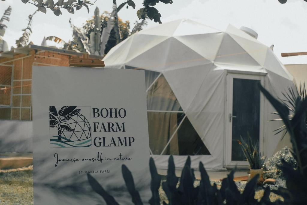 une tente blanche avec un panneau devant elle dans l'établissement Boho Farm Glamp, à Santo Tomas