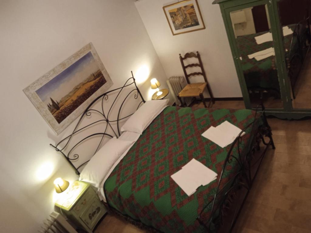 una camera con letto e piumone verde di La casa di sally a Pitigliano