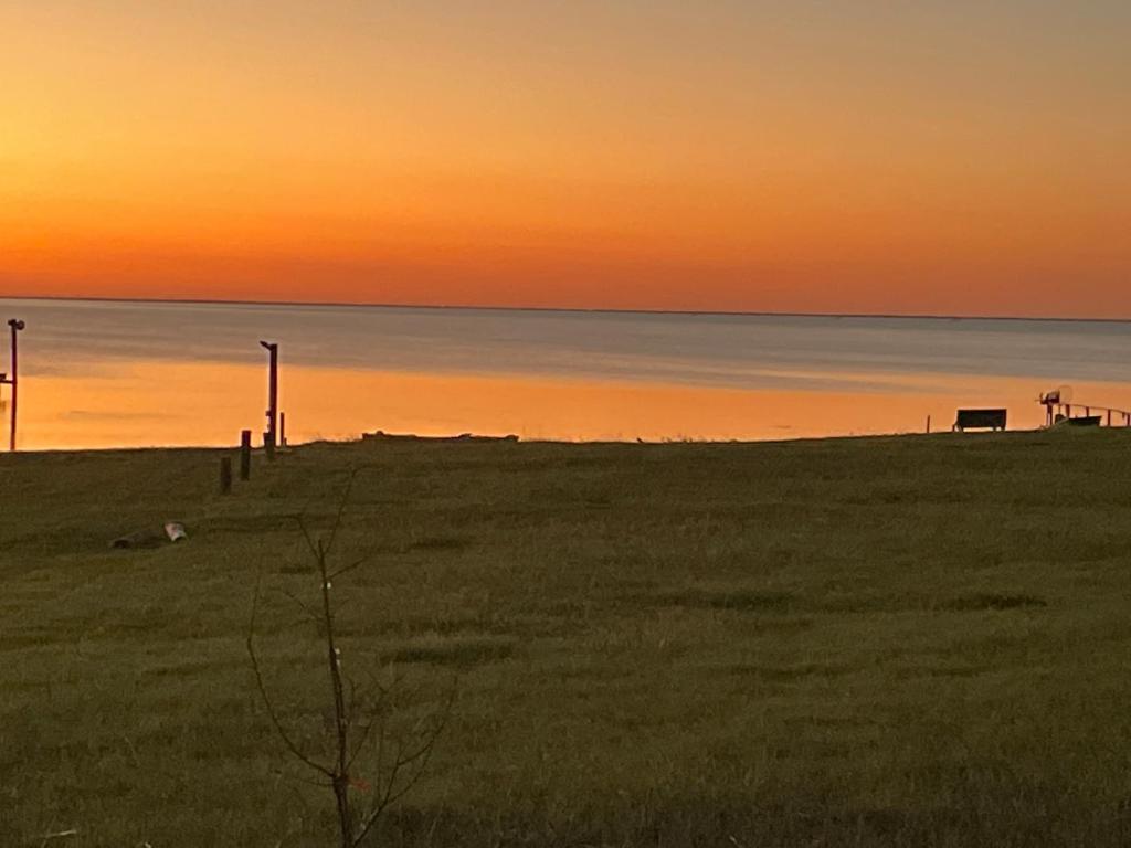 - un coucher de soleil sur un champ avec un banc sur la plage dans l'établissement April ‘s Family Getaway, à Rockport