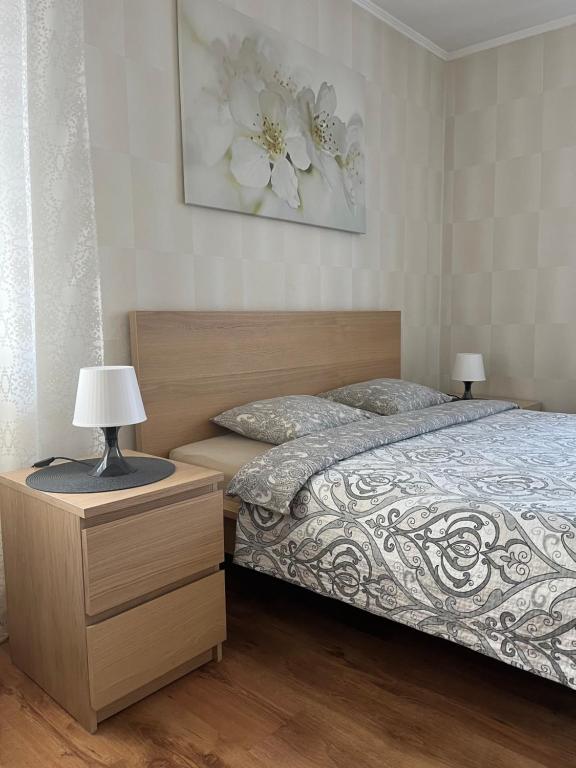 ein Schlafzimmer mit einem Bett und zwei Lampen auf einem Nachttisch in der Unterkunft Imantas apartment in Daugavpils