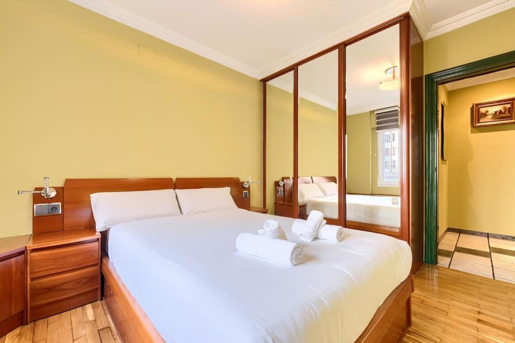 a bedroom with a large white bed with two towels at San Mamés Football & Parking in Bilbao