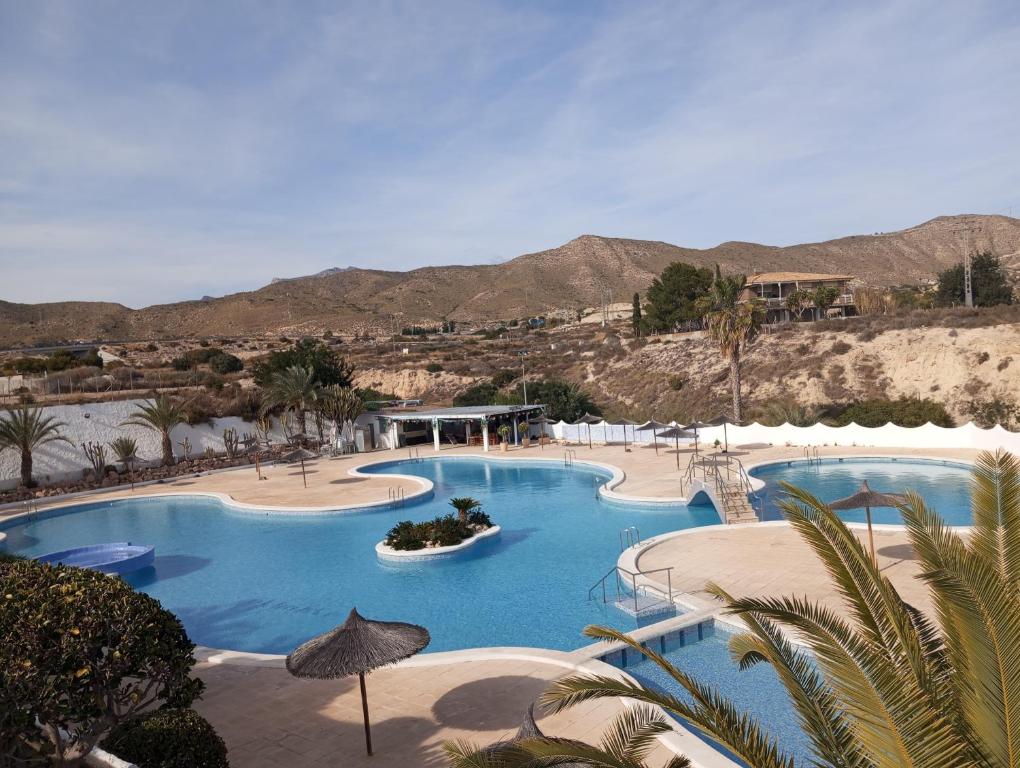 una gran piscina en un complejo con montañas en el fondo en Casa Alkabir Campello, en El Campello