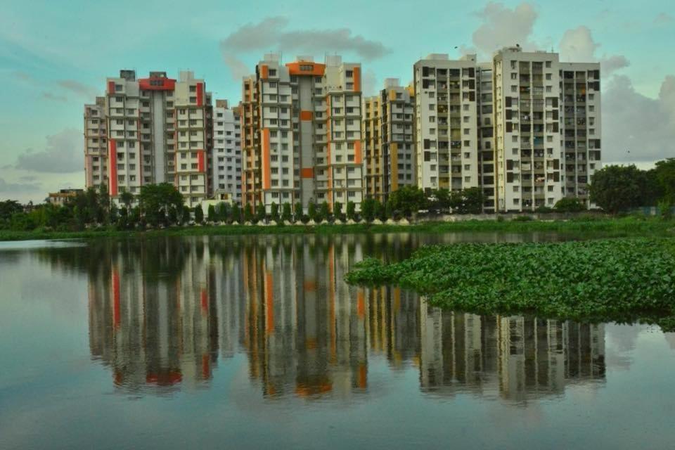 a group of apartment buildings next to a body of water at South-East-West Facing 3 BHK Lakeview Flat Howrah West Bengal in Howrah