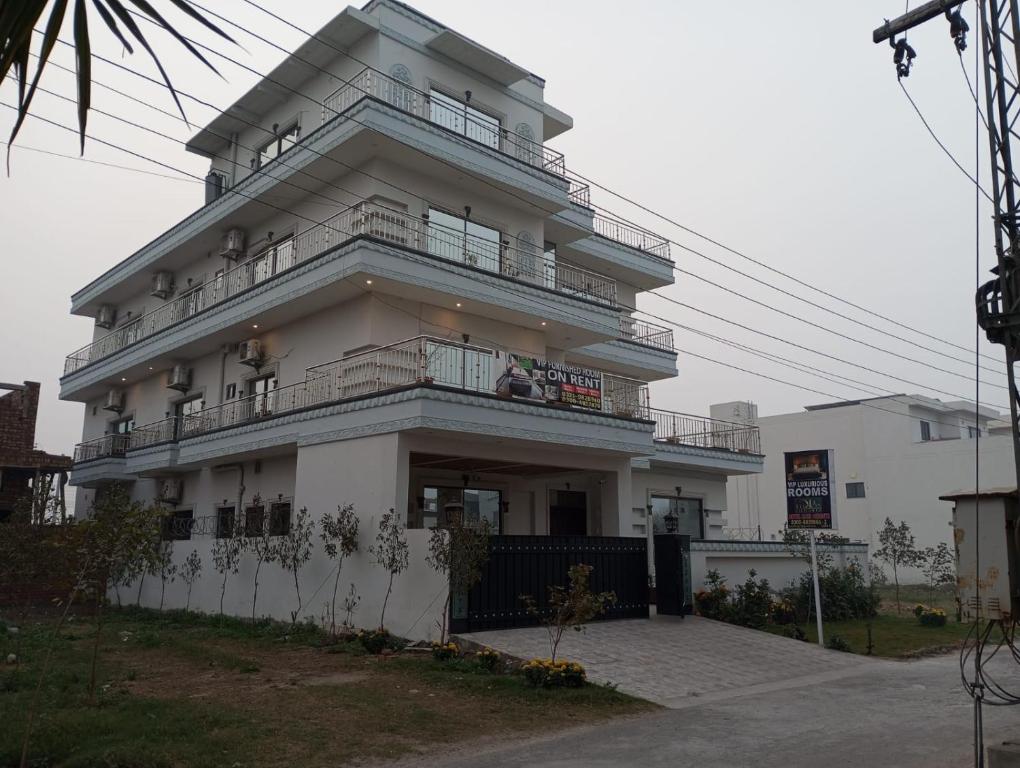 a large white building with balconies on top of it at Hotel Luxe Heights Lahore in Lahore