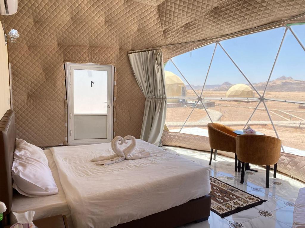 a bedroom with a bed with two swans on it at Rum Aranda camp & Jeep Tour in Wadi Rum