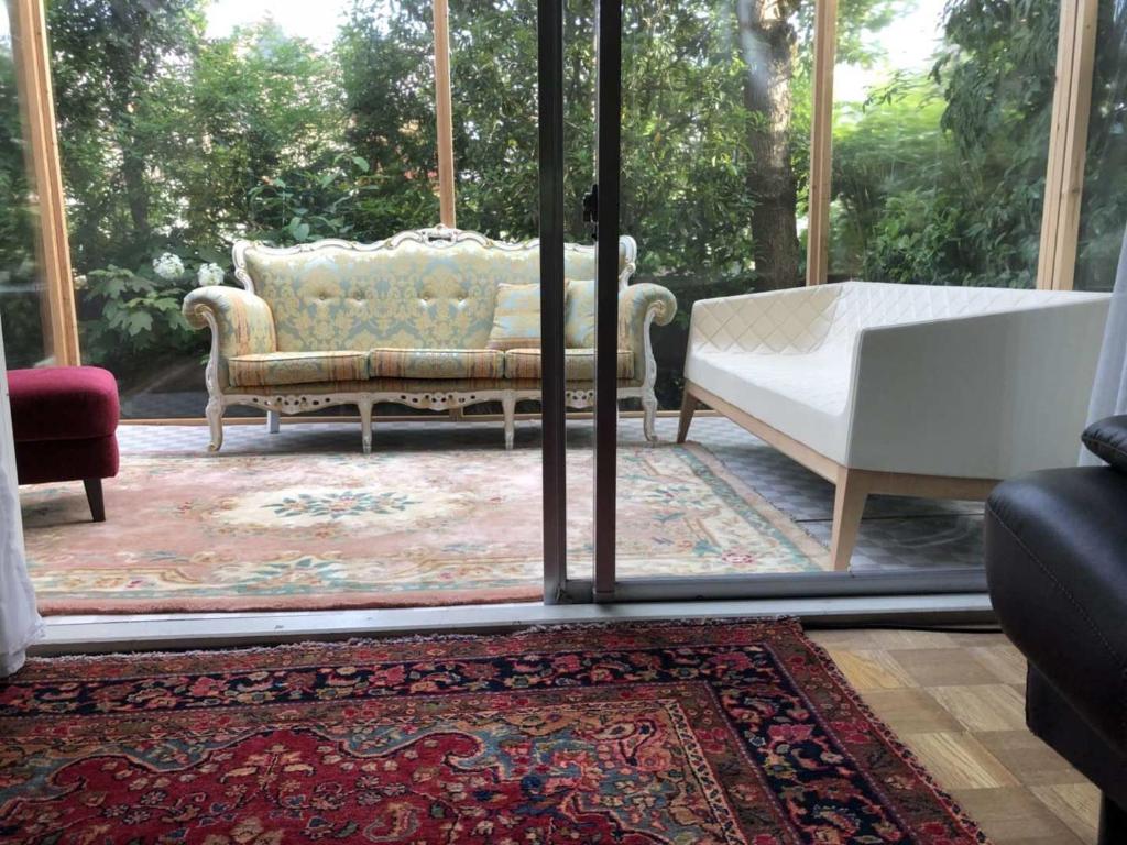 a living room with a couch and a window at Kashiwanoha Hotspring Garden Villa&Suite Room in Kashiwa