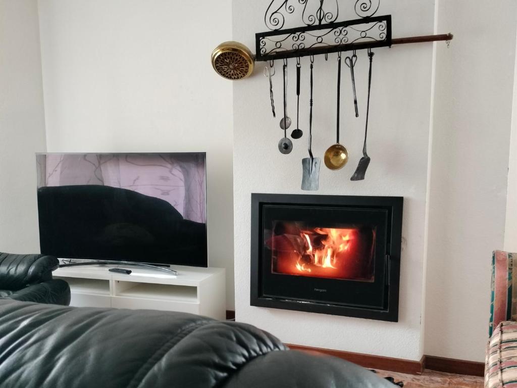 sala de estar con chimenea y TV en Villa Manolo, en Guadarrama
