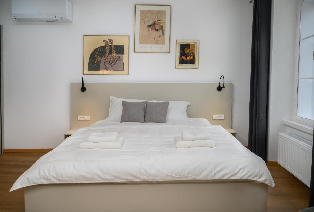 a large white bed with two pillows on it at Primus apartments in Ljubljana