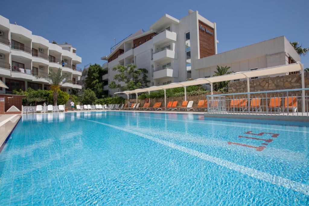 a swimming pool in a hotel with chairs and buildings at Side Resort Annex in Side