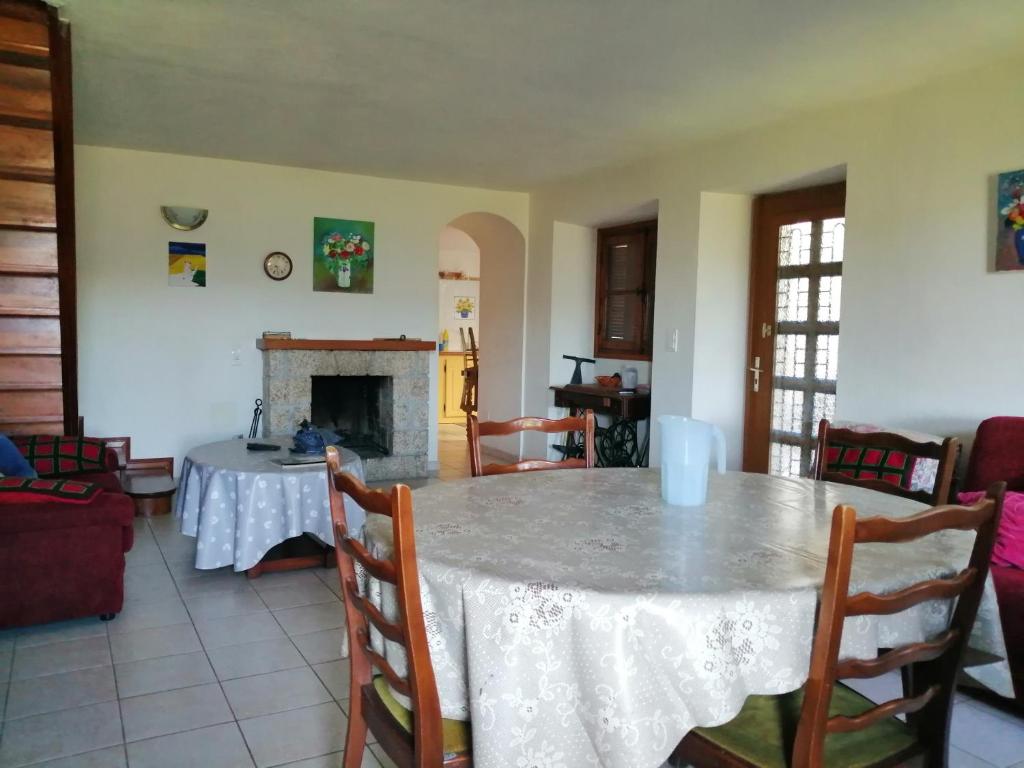 een eetkamer met een tafel en een open haard bij Maison de village calme et agréable in Albitreccia