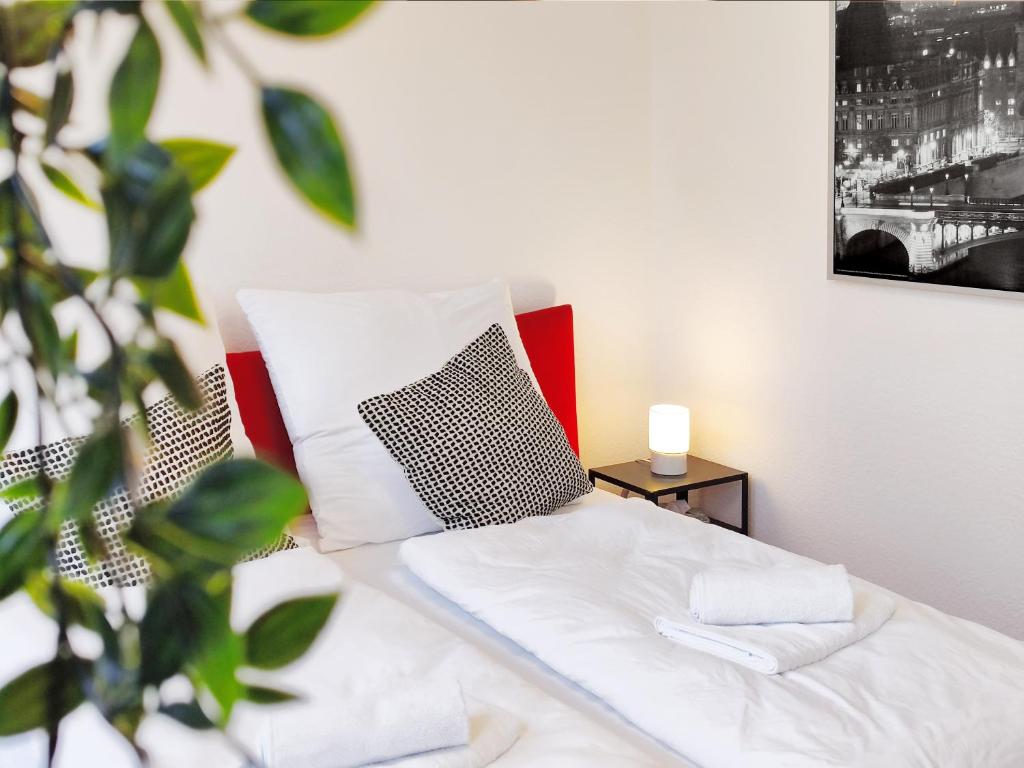 uma cama com lençóis brancos e uma almofada a preto e branco em Ruhe und Komfort in Magdeburg em Magdeburg