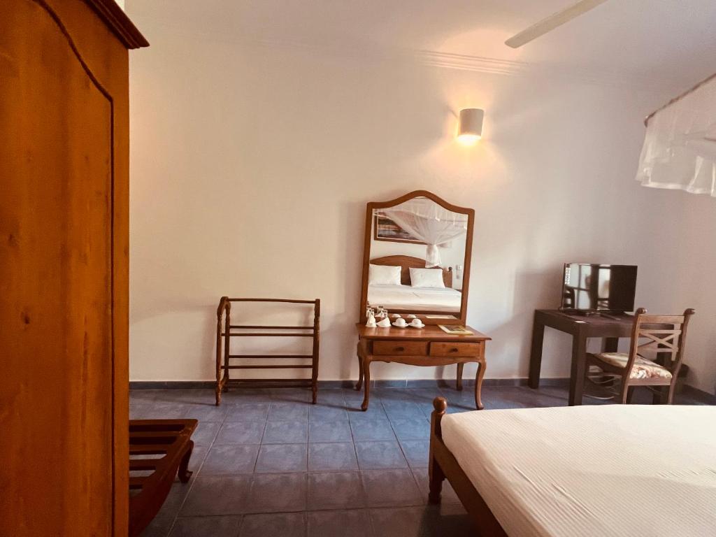 um quarto com um espelho e um toucador em Muthumuni Ayurveda River Resort em Aluthgama