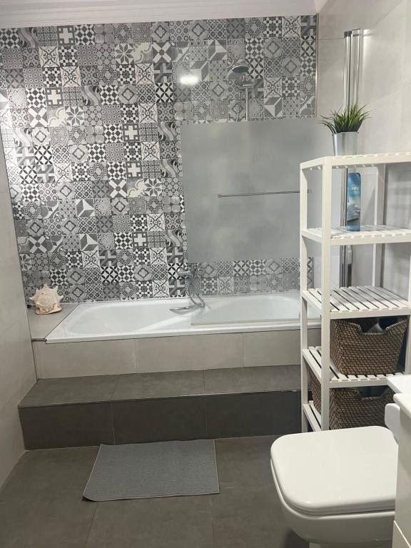 een badkamer met een ligbad en een toilet bij Casa Pom at the Beach in Torre de Benagalbón