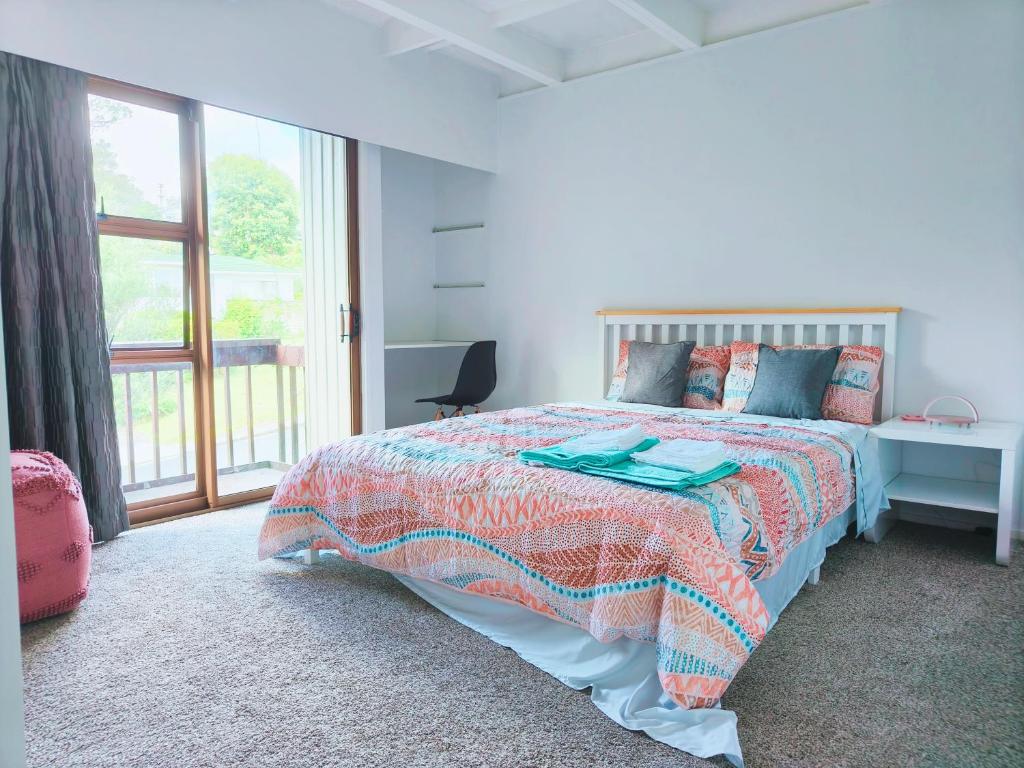 um quarto branco com uma cama e uma janela em Sunny Cosy stay in Auckland em Auckland