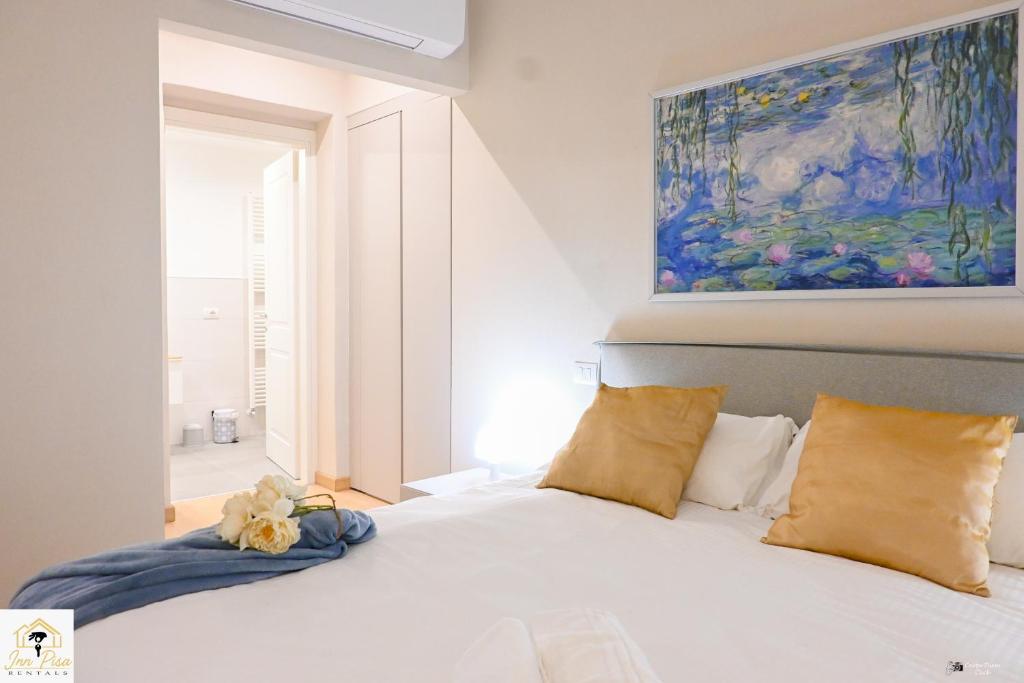 a bedroom with a white bed with a painting above it at Inn Pisa Rentals - Pisa Tower Flat in Pisa