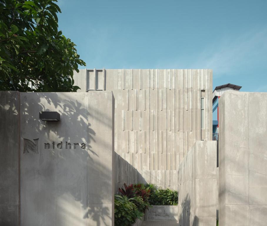 a concrete fence with a building in the background at Nidhra Boutique in Bangkok