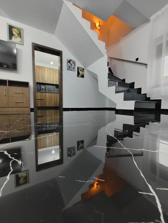 een trap in een kamer met zwarte en witte vloeren bij Black&White House in Ocna-Mureşului