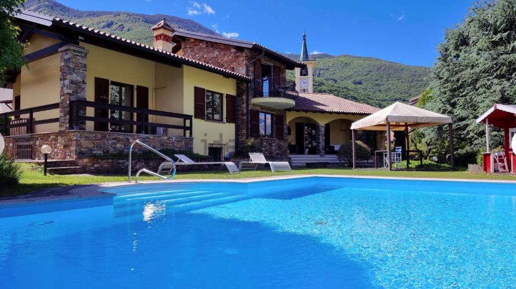 a house with a swimming pool in front of a house at Suite with Lake Como view in Colico