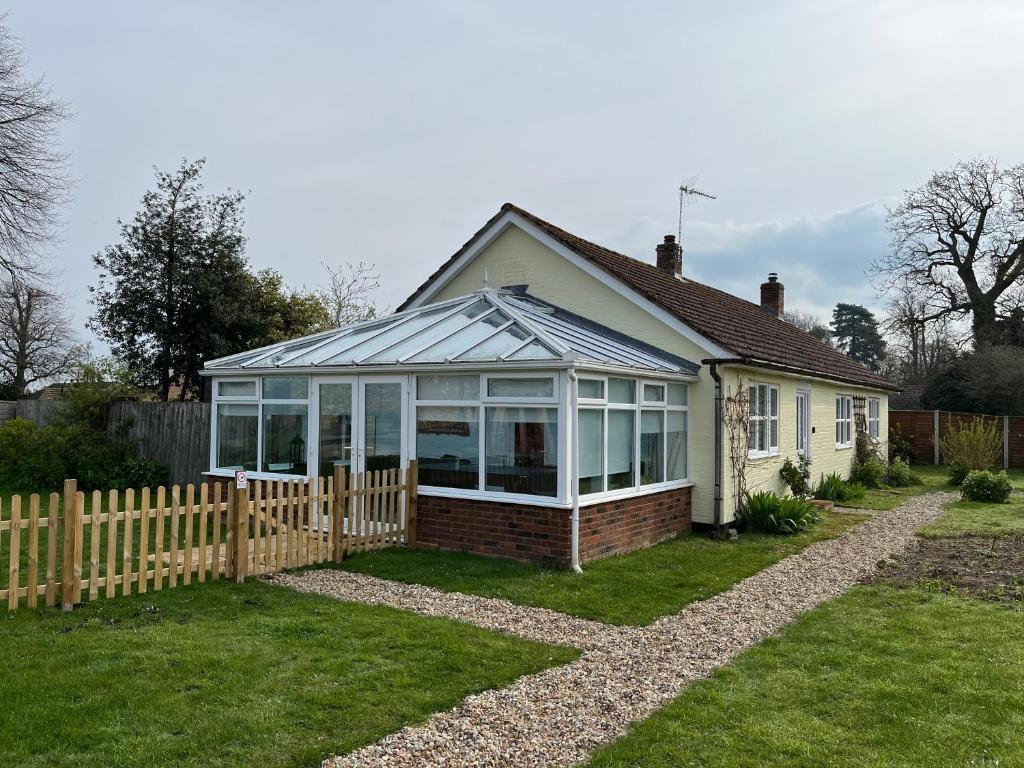 a house with a conservatory with a wooden fence at Greengates of Shouldham in Shouldham