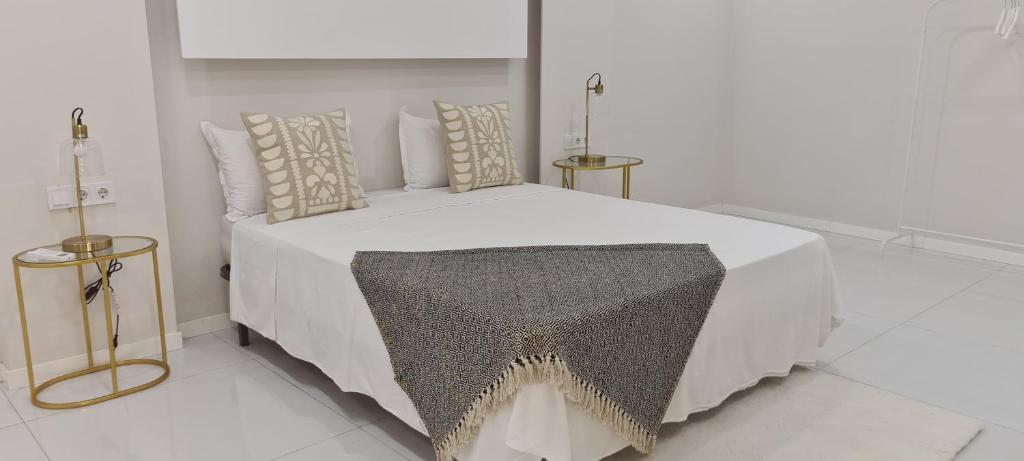 ein Schlafzimmer mit einem weißen Bett mit Kissen in der Unterkunft Cazinos Apartamento 2 in Praia