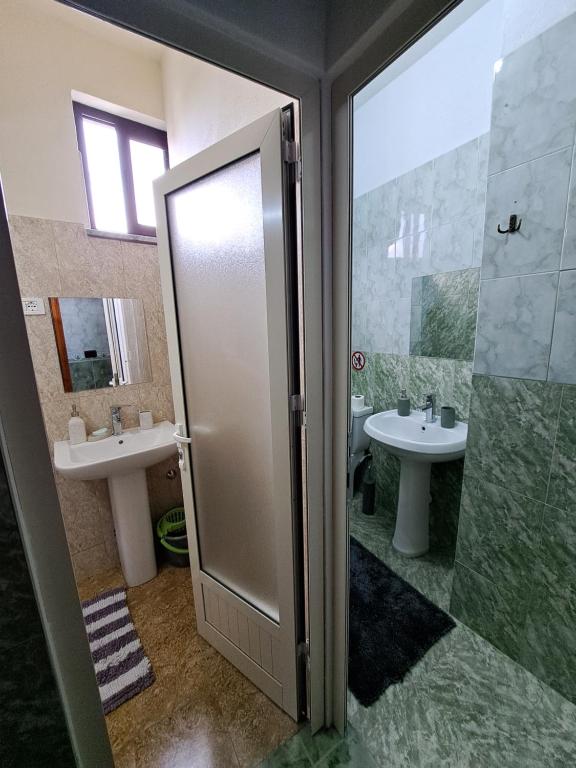 ein Bad mit 2 Waschbecken und einer Dusche in der Unterkunft The house of dreams 2 in Shkodra