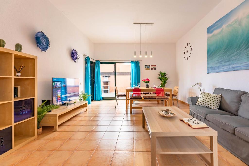 a living room with a couch and a table at Sunrise Surf House, Big Garden, Hot Tub, Parking, super-fast free Wi-Fi in Corralejo