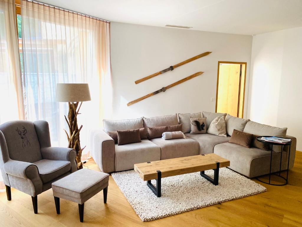 uma sala de estar com um sofá e uma mesa de centro em Luxus-Mountain-Suite Belvita mit Sauna em Flims