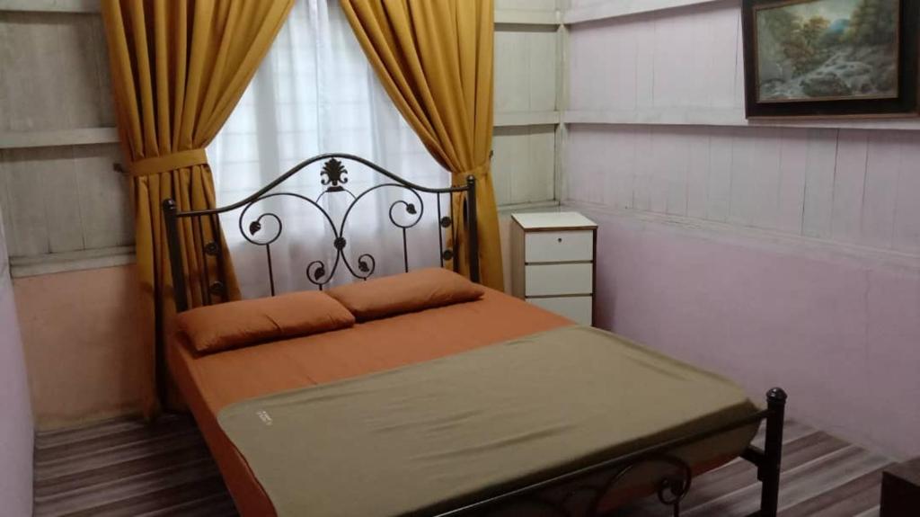 a bedroom with a bed and a window with curtains at Homestay Bonda Azizah 11-13pax in Kota