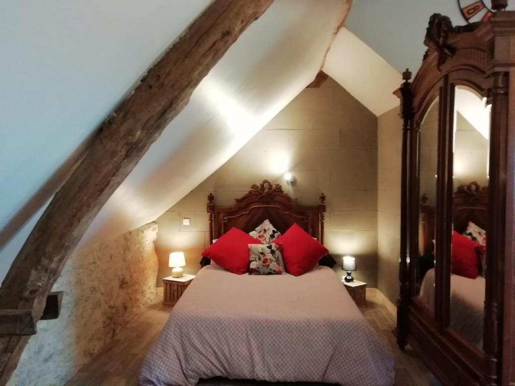 a bedroom with a large bed with red pillows at Le Fenil in Floirac