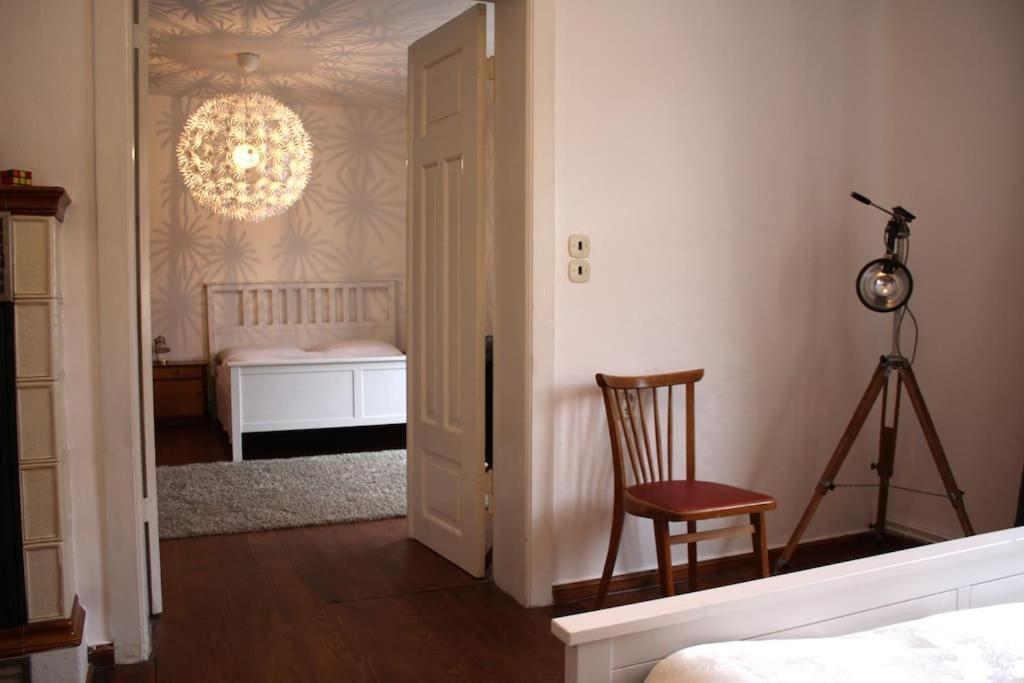 una camera con letto, sedia e lampadario a braccio di Ferienwohnung mit großem Garten und Blick zum See a Fürstenwerder