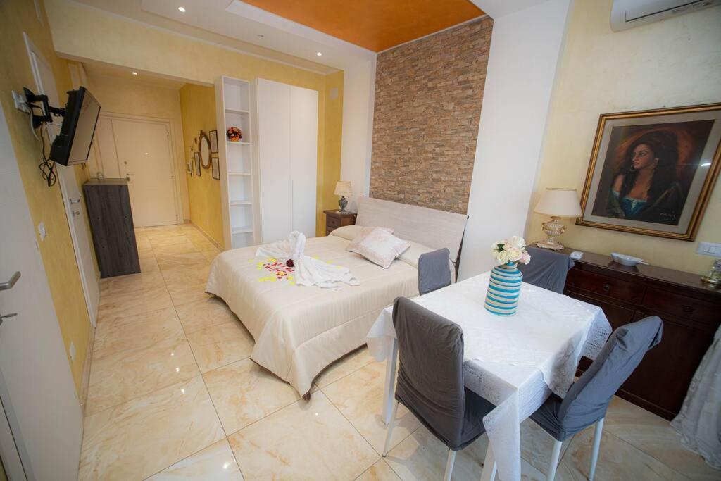 um quarto com uma cama, uma mesa e cadeiras em Appartamento La Coccinella em Lido di Ostia