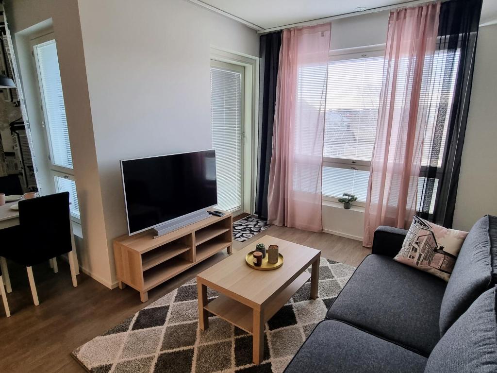 a living room with a couch and a tv at Upea huoneisto Rauman keskustassa in Rauma