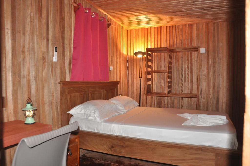 a bedroom with a bed and a desk and a red window at KSW BASE NAUTIQUE Isonalambo in Kribi